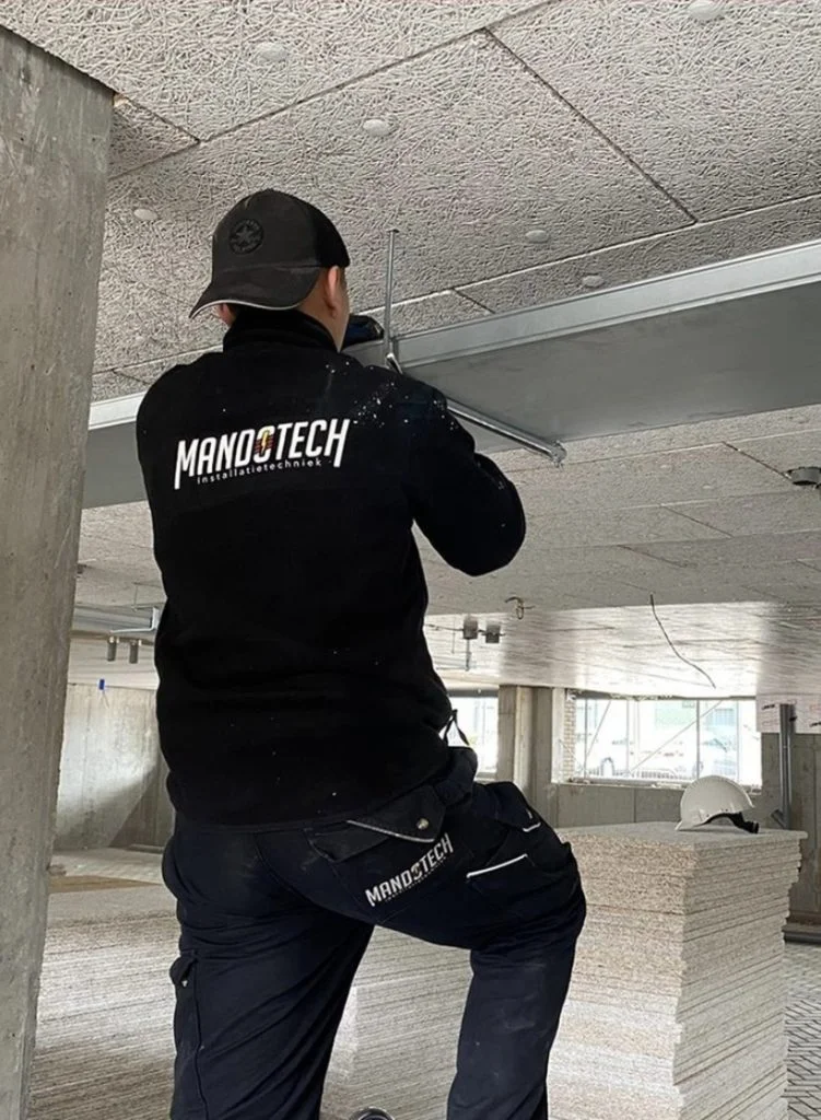 Mandotech monteur aan het werk aan een plafondinstallatie